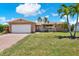Charming single-story home with a brick driveway, two-car garage, and well-manicured front lawn at 11628 Grove St, Seminole, FL 33772
