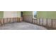 An unfinished living room with concrete floors features a window and partial wall construction at 11628 Grove St, Seminole, FL 33772