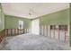 A large unfinished living room features a ceiling fan, window, and sliding glass door at 11628 Grove St, Seminole, FL 33772