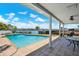A covered patio featuring an outdoor swimming pool overlooks water and harbor views at 11628 Grove St, Seminole, FL 33772
