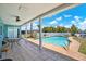A covered patio with an outdoor swimming pool overlooks lush green landscaping at 11628 Grove St, Seminole, FL 33772