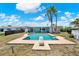 An outdoor swimming pool with a diving board sits behind a home with tropical trees at 11628 Grove St, Seminole, FL 33772
