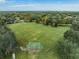 Expansive green field surrounded by lush trees, offering a serene and picturesque landscape at 11706 Gilmerton Dr, Riverview, FL 33579