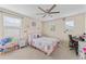 Cozy bedroom with a ceiling fan, window, and a pink decorative theme at 11706 Gilmerton Dr, Riverview, FL 33579