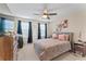 Comfortable bedroom with ceiling fan, window, dresser, and neutral carpet at 11706 Gilmerton Dr, Riverview, FL 33579