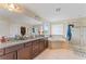 Main bathroom featuring double vanity, soaking tub, and glass-enclosed shower at 11706 Gilmerton Dr, Riverview, FL 33579