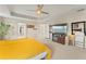 Bright main bedroom featuring a tray ceiling, ceiling fan, and ensuite bathroom at 11706 Gilmerton Dr, Riverview, FL 33579