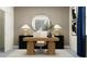 Bright home office with a modern wood desk, sleek decor, stylish lamp, and a circular mirror for a sophisticated work space at 11761 E 71St Ter, Palmetto, FL 34221