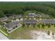 Aerial view of a complex of well-maintained townhomes next to a wooded conservation area at 11903 Greengate Dr, Hudson, FL 34669