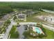 Aerial view of a complex of well-maintained townhomes next to a community pool and wooded areas at 11903 Greengate Dr, Hudson, FL 34669