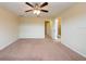 Bedroom with neutral carpet, ceiling fan and ensuite bathroom access at 11903 Greengate Dr, Hudson, FL 34669