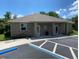 Charming clubhouse exterior featuring stone accents, covered entrances, and convenient parking with bicycle rack at 11903 Greengate Dr, Hudson, FL 34669