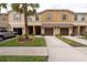 Inviting townhome featuring a two-car garage, neutral paint scheme, and manicured landscaping at 11903 Greengate Dr, Hudson, FL 34669