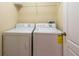 Convenient laundry room featuring a washer and dryer with a wire shelf above at 11903 Greengate Dr, Hudson, FL 34669