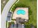 Aerial shot of community pool and seating with tropical landscaping, parking and green space at 11903 Greengate Dr, Hudson, FL 34669