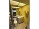 Bathroom features patterned yellow wallpaper, tiled floor, white fixtures, and a large mirror above the sink at 1200 37Th N St # 403, St Petersburg, FL 33713