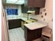 Cozy kitchen with dark cabinetry, laminate countertops, a small island, and matching white appliances at 1200 37Th N St # 403, St Petersburg, FL 33713