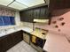 Kitchen with laminate countertops, dark wood cabinets and vintage yellow and black appliances at 1200 37Th N St # 403, St Petersburg, FL 33713