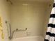 Shower with a chrome grab bar and neutral tile, and a soap dish for accessibility and convenience at 1200 37Th N St # 403, St Petersburg, FL 33713