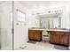 Well-lit bathroom featuring a double vanity, large mirror, and a glass-enclosed shower at 12279 Elmore Dr, Spring Hill, FL 34609