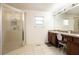 Well-lit bathroom featuring a double vanity, large mirror, and a glass-enclosed shower at 12279 Elmore Dr, Spring Hill, FL 34609