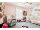 Charming pink bedroom featuring a floral accent wall, soft carpet, and playful decor at 12279 Elmore Dr, Spring Hill, FL 34609