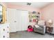 Cozy bedroom featuring a white dresser, gray chair with books, and ample closet space at 12279 Elmore Dr, Spring Hill, FL 34609