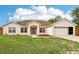 Well-maintained single-Gathering home with a manicured lawn, attached garage, and charming front entrance at 12279 Elmore Dr, Spring Hill, FL 34609