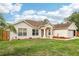 Charming single-story home with a well-manicured lawn, columned porch, and attached garage at 12279 Elmore Dr, Spring Hill, FL 34609