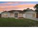 Well-maintained home showcasing manicured lawn and inviting entrance, displaying curb appeal and charm at 12279 Elmore Dr, Spring Hill, FL 34609