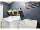 Clean laundry area features modern washer and dryer, utility sink, floating shelf, and 