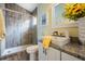 Bathroom featuring tile flooring, granite counters, a modern vanity, and a tiled glass shower at 12813 Kings Lake Dr, Gibsonton, FL 33534
