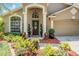 Charming front entrance with a well-manicured lawn, sculpted shrubbery, and a welcoming front door at 12813 Kings Lake Dr, Gibsonton, FL 33534