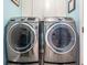 Bright laundry room featuring a gray front-loading washer and dryer at 12813 Kings Lake Dr, Gibsonton, FL 33534