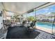 View of the screened patio with outdoor furniture overlooking the pristine pool at 12813 Kings Lake Dr, Gibsonton, FL 33534