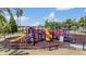 Bright and colorful community playground with slides, climbing structures, and benches, surrounded by mulch at 12813 Kings Lake Dr, Gibsonton, FL 33534