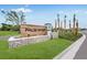 Palm Wind community entrance sign featuring a stone base, wood facade, landscaping, and tall palms at 13570 Tropical Breeze Way, Hudson, FL 34669