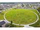 Aerial view of a spacious circular green space surrounded by walking paths in a residential community at 13603 Wild Ginger St, Riverview, FL 33579
