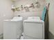 Functional laundry room equipped with a washer, dryer, and storage shelves for convenience at 13603 Wild Ginger St, Riverview, FL 33579
