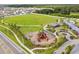 Aerial view of a neighborhood playground with slides, swings, and green spaces surrounded by homes at 13603 Wild Ginger St, Riverview, FL 33579