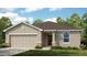 Charming single-story home featuring a neutral color palette, well-manicured lawn, and an attached two-car garage at 13621 Tropical Breeze Way, Hudson, FL 34669