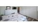 This bedroom features a bed with pillows, closet doors, and a dresser at 14204 Yacht Club Blvd, Seminole, FL 33776
