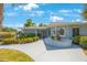Close-up of single-story home featuring well-maintained landscaping, walkway, and decorative brickwork at 14204 Yacht Club Blvd, Seminole, FL 33776