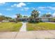 Charming single-story home with mature landscaping, palm trees and walkway leading to front door at 14204 Yacht Club Blvd, Seminole, FL 33776