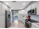 Bright kitchen featuring modern appliances, white cabinets, and granite countertops at 14204 Yacht Club Blvd, Seminole, FL 33776