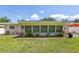A cozy backyard features a screened-in sunroom, a small patio, and a well-maintained lawn for outdoor relaxation at 1445 Wilson Rd, Clearwater, FL 33755