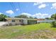 Spacious backyard with a brick patio and lush green grass surrounding the house at 1445 Wilson Rd, Clearwater, FL 33755