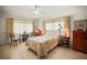 Cozy bedroom with tile floors, ceiling fan, matching curtains, and bedspread in a floral pattern at 1445 Wilson Rd, Clearwater, FL 33755