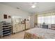 Bright bedroom with tile floors, floral bedspread, dresser, and an expansive mirror at 1445 Wilson Rd, Clearwater, FL 33755