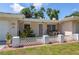 Inviting front porch with a white lattice fence and seating area, offering a cozy outdoor space at 1445 Wilson Rd, Clearwater, FL 33755